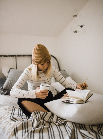 ベッドの上で勉強する女性