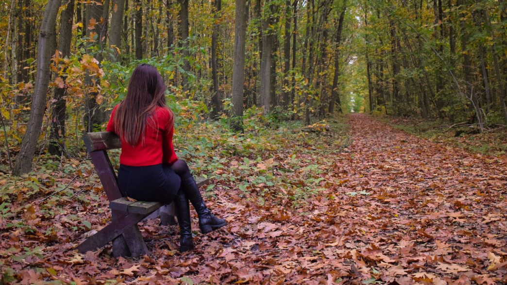 秋の落ち葉の中で佇む女性